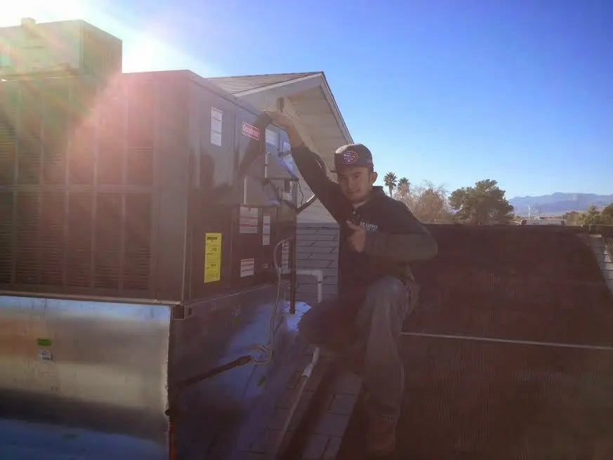 HVAC technician performing AC Tune-Up on a rooftop unit in Villa Rica
